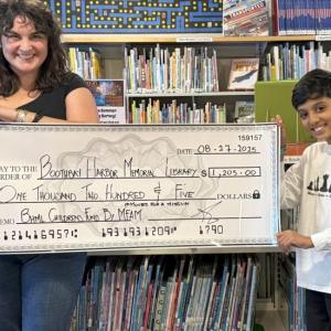 Boothbay Harbor Memorial Library Executive Director Joanna Breen accepts a $1,205 oversized check Aug. 26 from Raza Patel who conducted his charity's Moves for a Mission fundraiser earlier in the month. Courtesy photo CHECK MATE